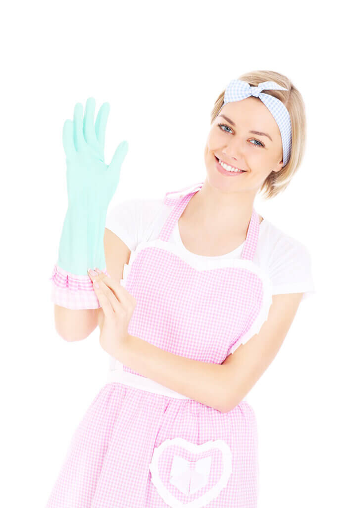 Alt Text: "A woman wearing a rubber glove and a pink apron, smiling at the camera.