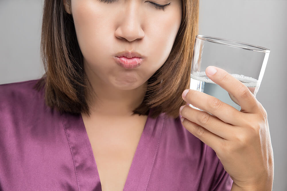 Image of a woman in pajamas gargling with food grade hydrogen peroxide.