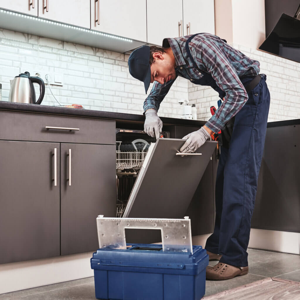 service male tech looking at washing machine 